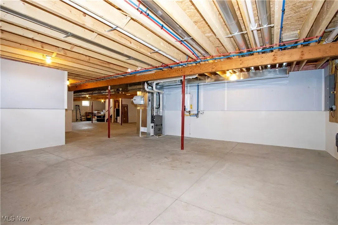 Unfinished below grade area featuring heating unit