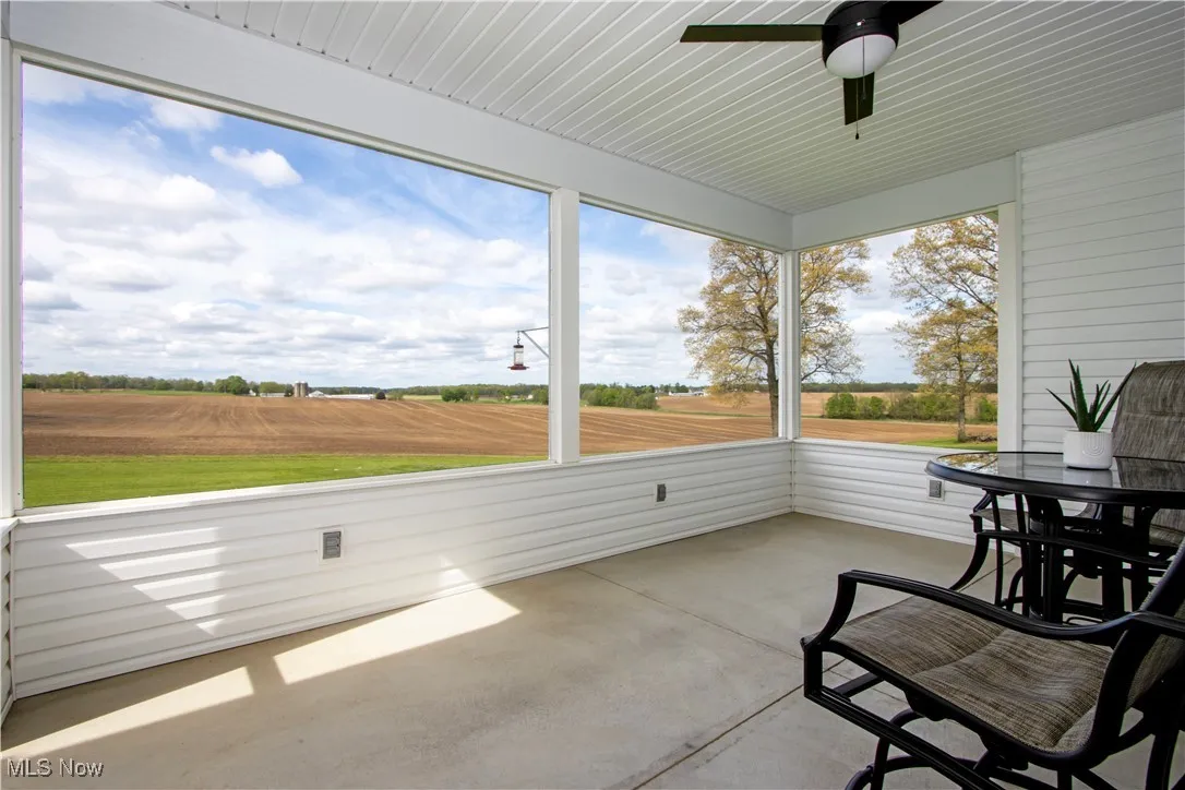 Screened in back porch with a ceiling fan