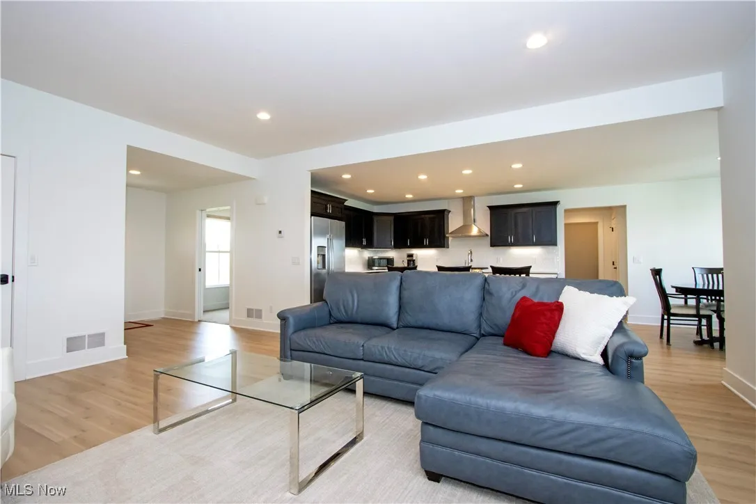 Living area with light wood-style flooring, baseboards, and recessed lighting