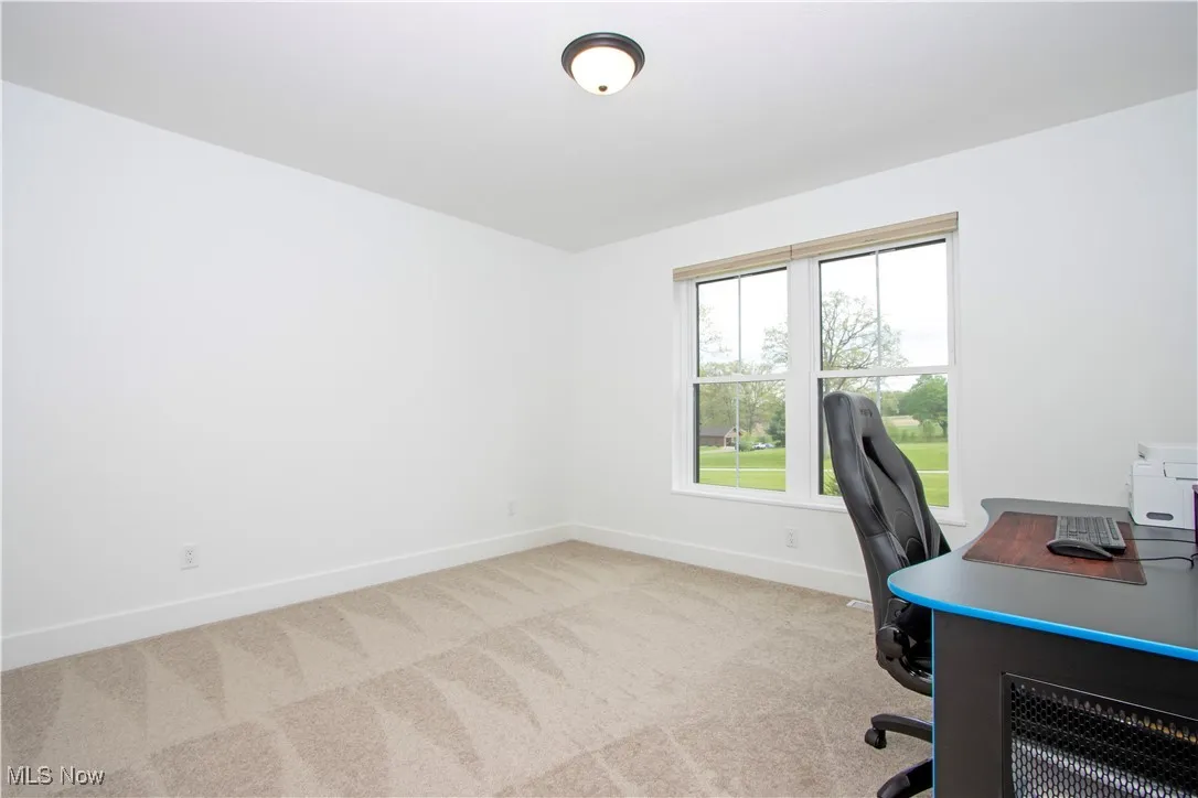 Carpeted office space with baseboards