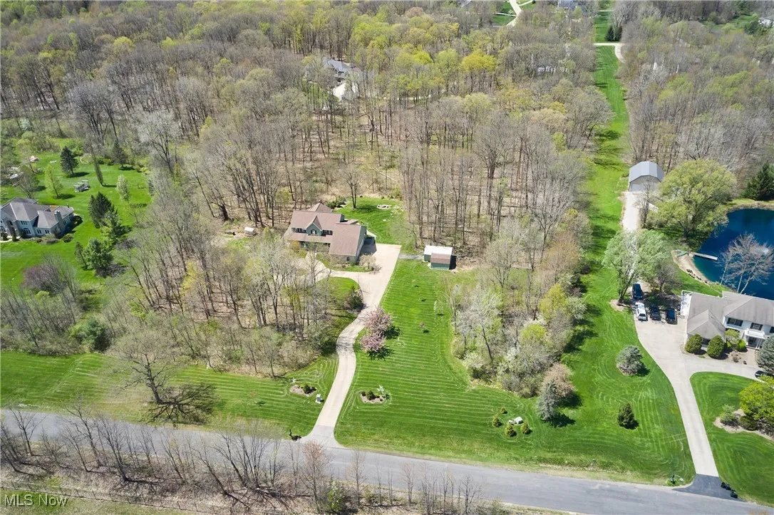 View of property location with a large body of water and a heavily wooded area
