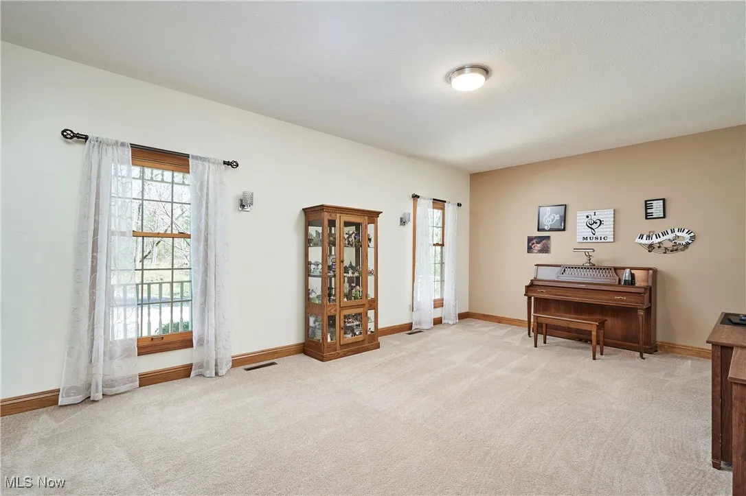 Living area with light carpet and baseboards