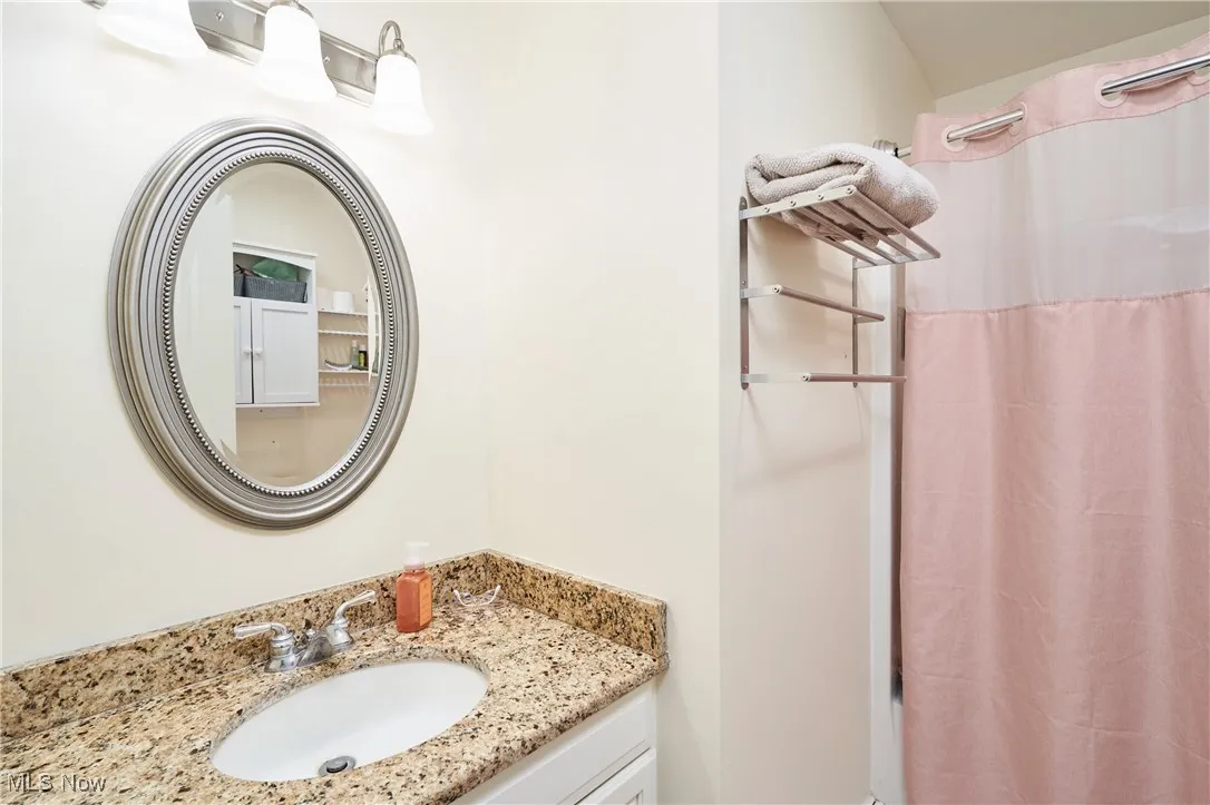 Full bath featuring vanity and curtained shower