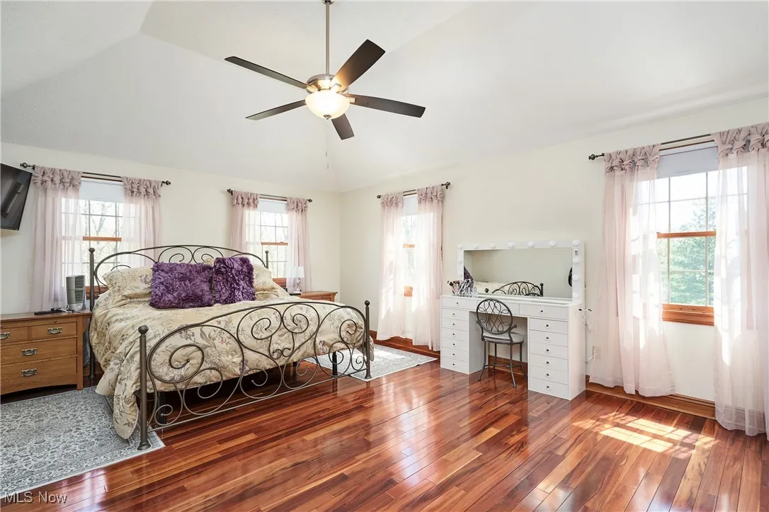 Bedroom featuring vaulted ceiling, hardwood / wood-style flooring, and ceiling fan