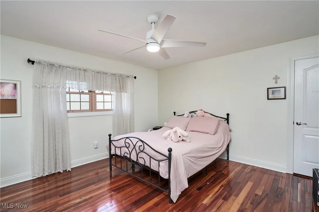 Bedroom featuring wood finished floors, baseboards, and ceiling fan