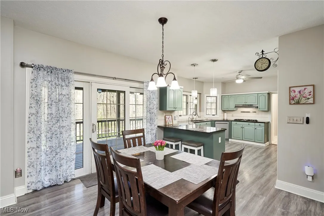 Dining room with baseboards, dark wood-style flooring, and a ceiling fan