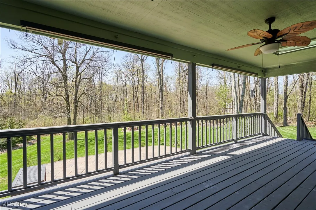 Wooden terrace featuring ceiling fan and a yard