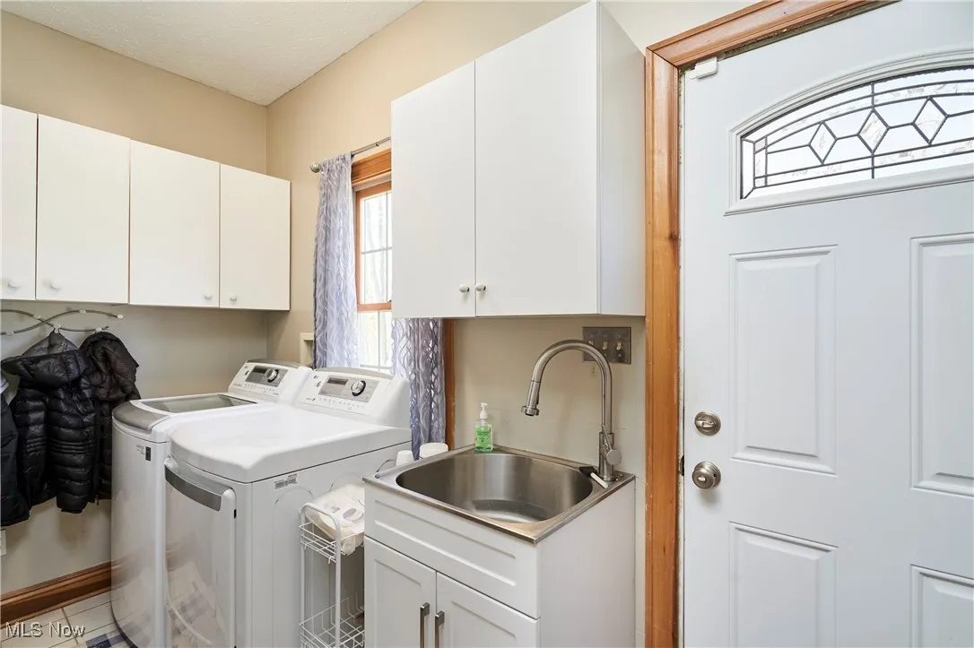 Laundry room featuring independent washer and dryer and cabinet space