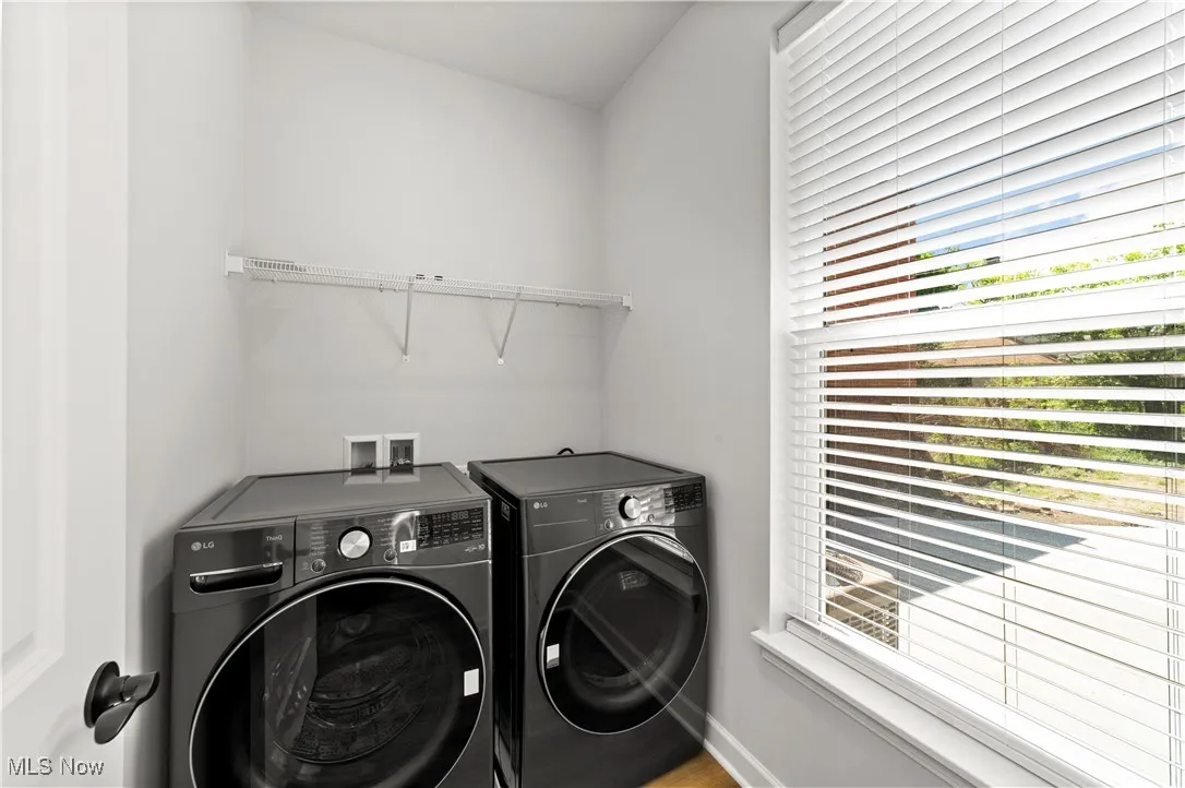 Laundry area with separate washer and dryer and baseboards