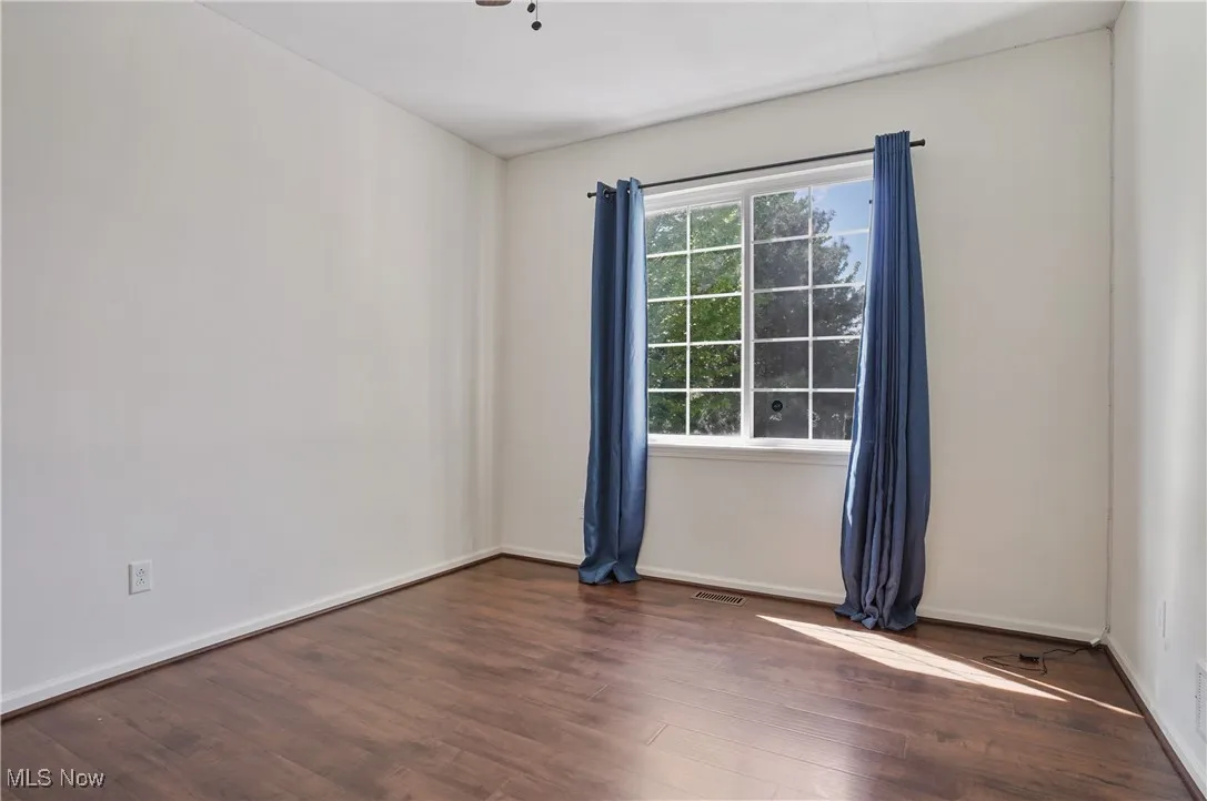 Spare room featuring visible vents, wood finished floors, and baseboards