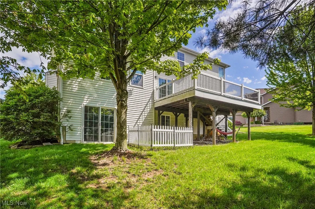 Rear view of property with a yard, a deck, and fence