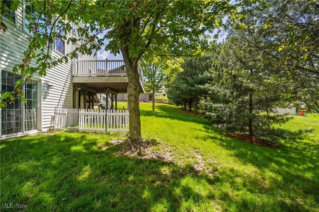 View of yard with fence and a wooden deck