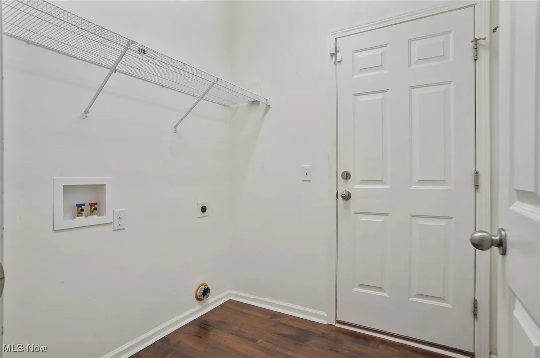Clothes washing area with laundry area, dark wood-style floors, electric dryer hookup, washer hookup, and baseboards