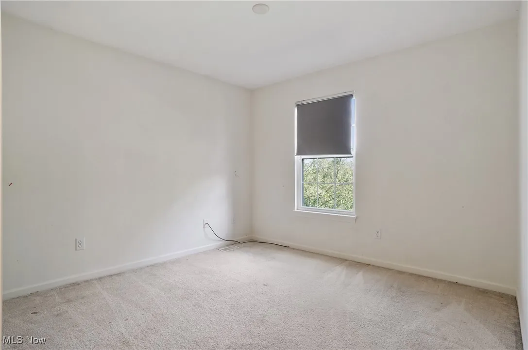 Unfurnished room featuring carpet and baseboards