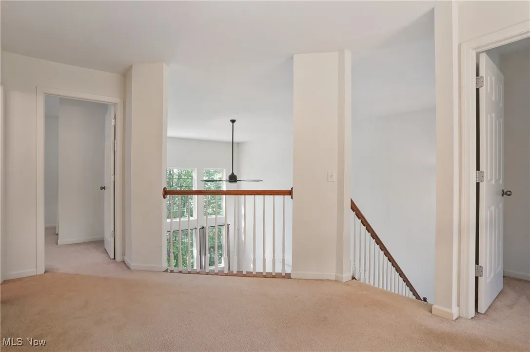 Corridor with baseboards, carpet flooring, and an upstairs landing