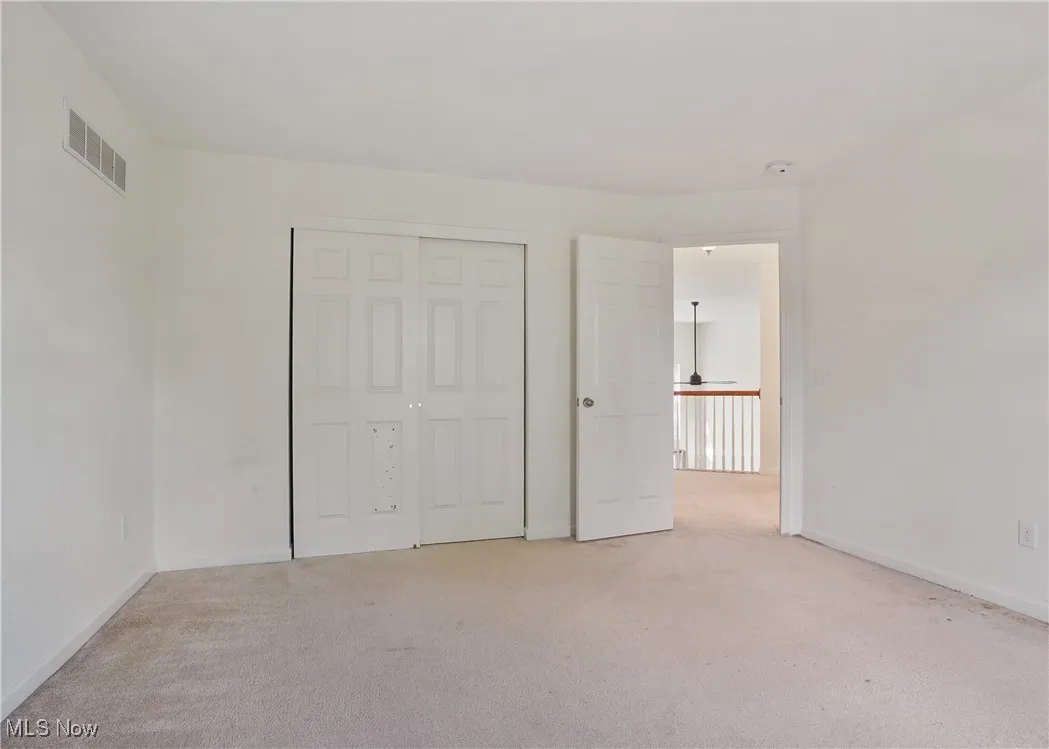 Unfurnished bedroom featuring light colored carpet, baseboards, and visible vents