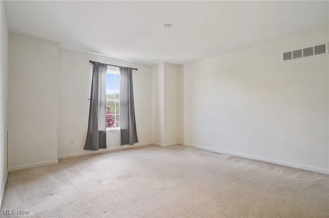 Carpeted spare room with baseboards and visible vents
