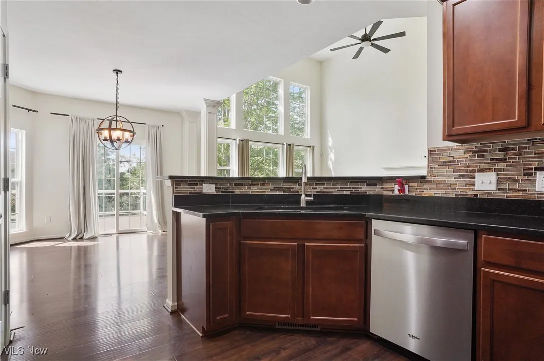 Kitchen with a wealth of natural light, a sink, stainless steel dishwasher, and tasteful backsplash