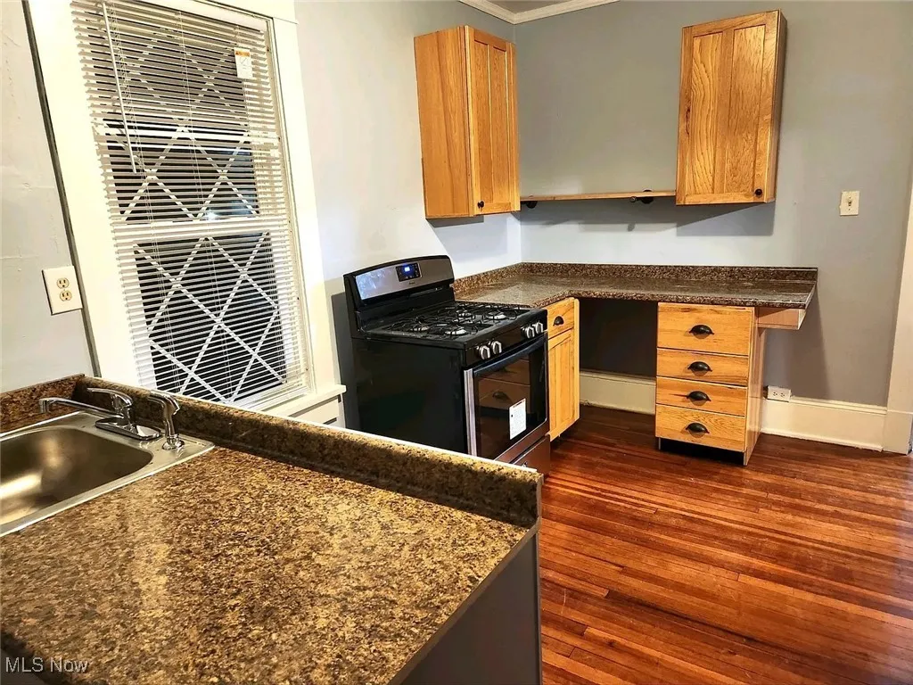 Unit 2: Kitchen with stainless steel range with gas stovetop, dark countertops, dark wood-style flooring, a sink, and open shelves