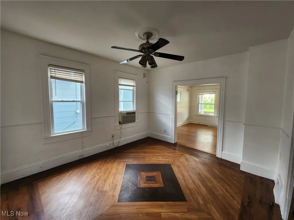 Unfurnished room with ceiling fan, baseboards, and cooling unit