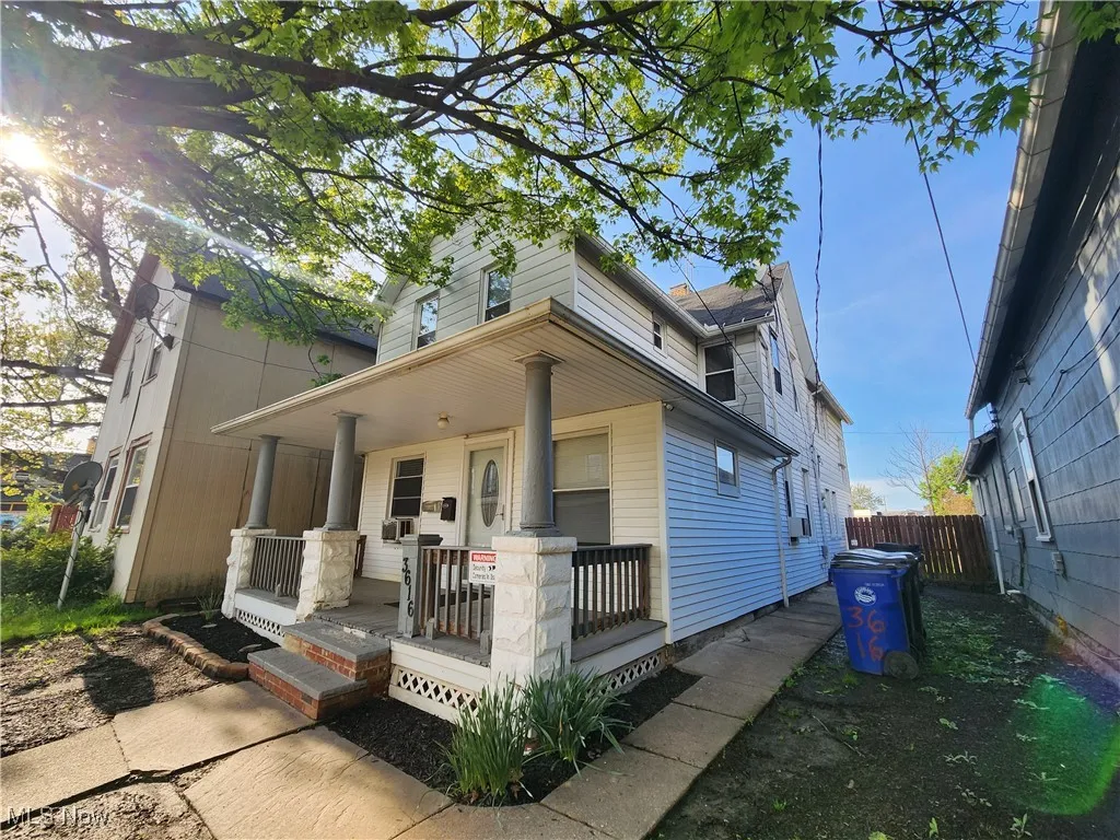 View of front of home with covered porch and fence