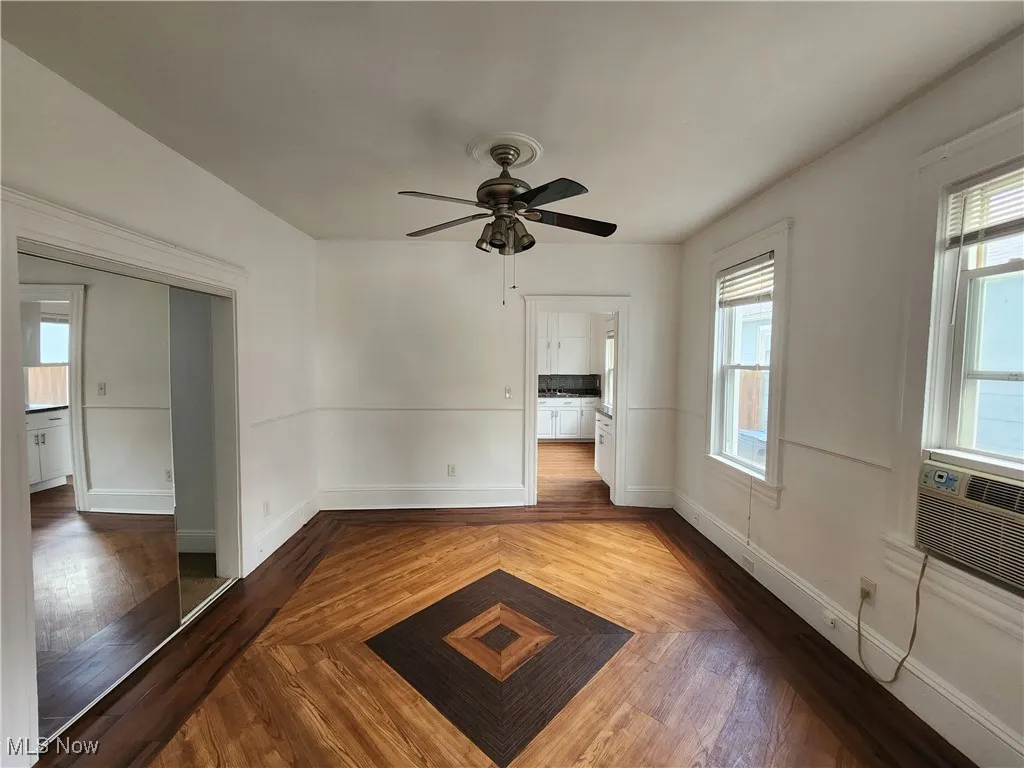 Spare room featuring ceiling fan, wood finished floors, and baseboards