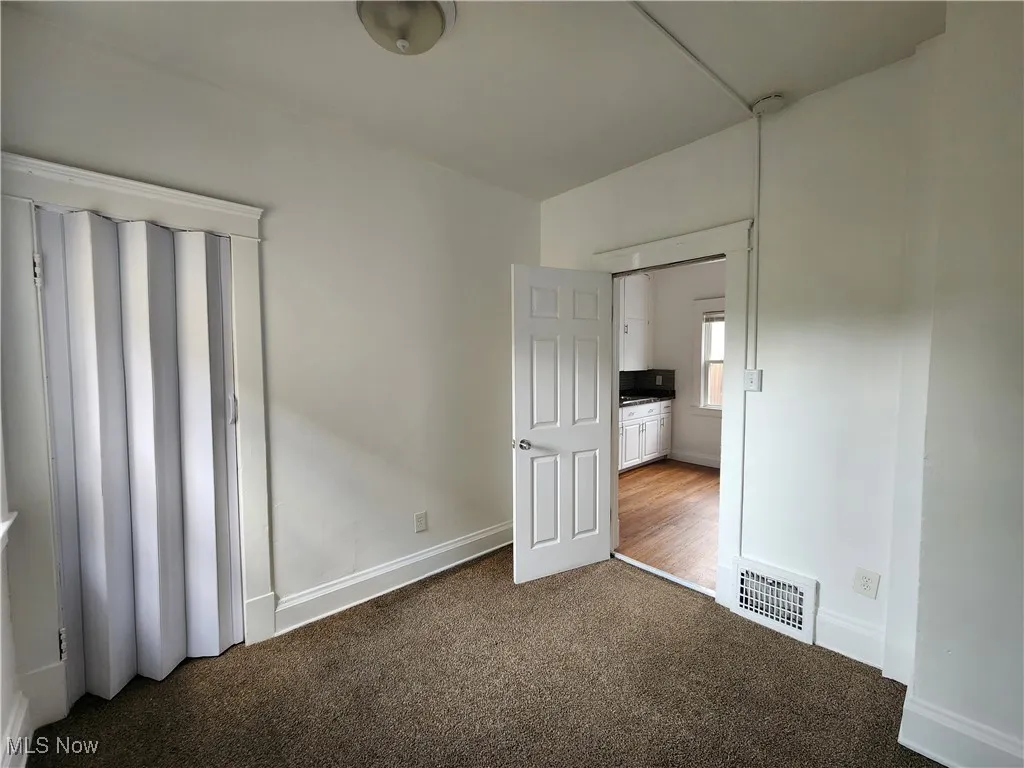 Unfurnished bedroom with carpet floors and baseboards