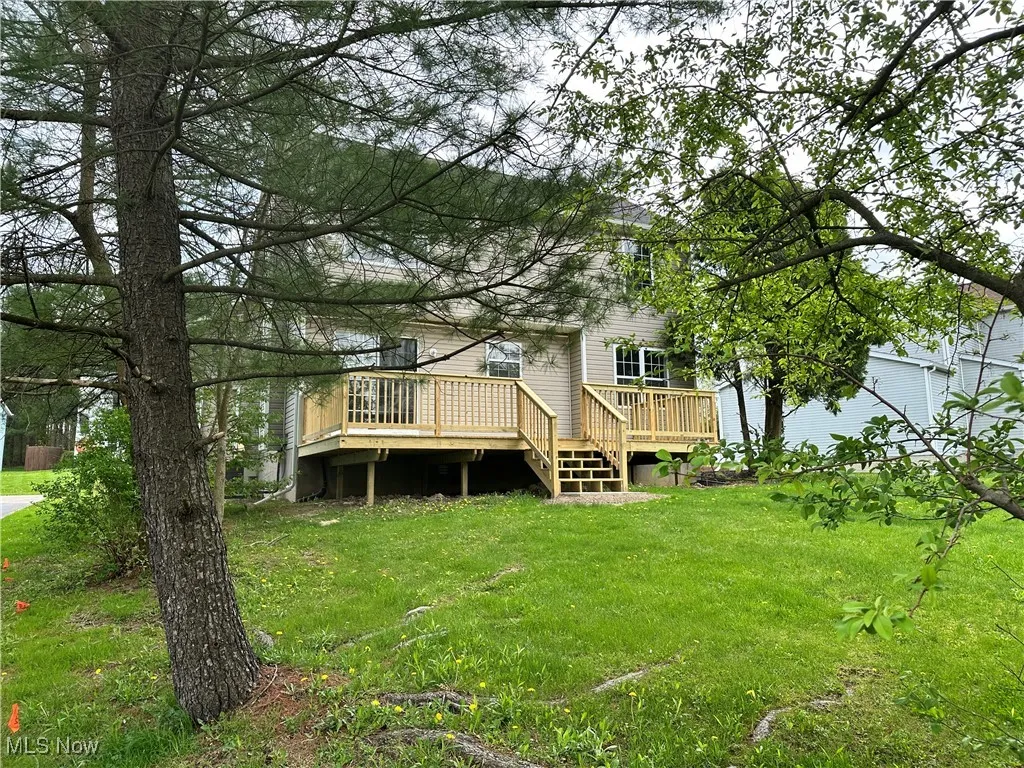 Back of property with a deck and a yard