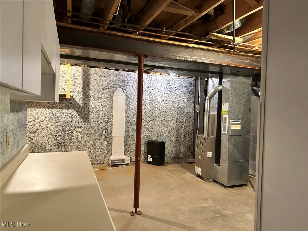 Unfinished below grade area featuring heating unit