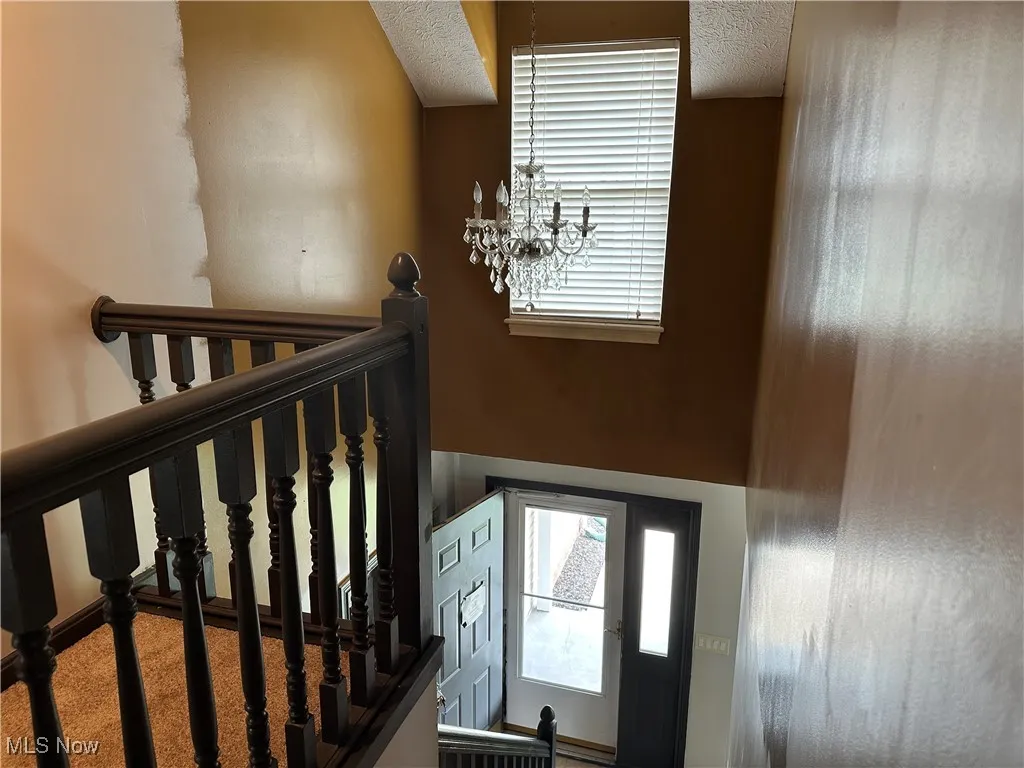 Stairs featuring a textured ceiling