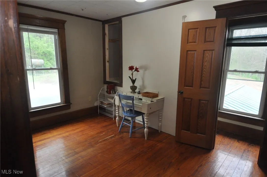 Second floor bedroom with dark wood finished floors and ornamental molding, rear door to back staircase to lower level and stairs to third floor