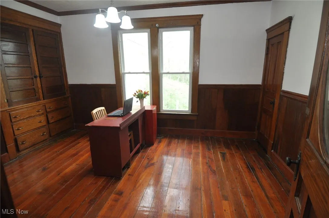Library/Home office with wainscoting, dark wood-style floors, wooden walls, crown molding