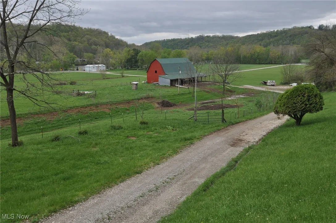 View of driveway, a rural view, a barn, and acreage