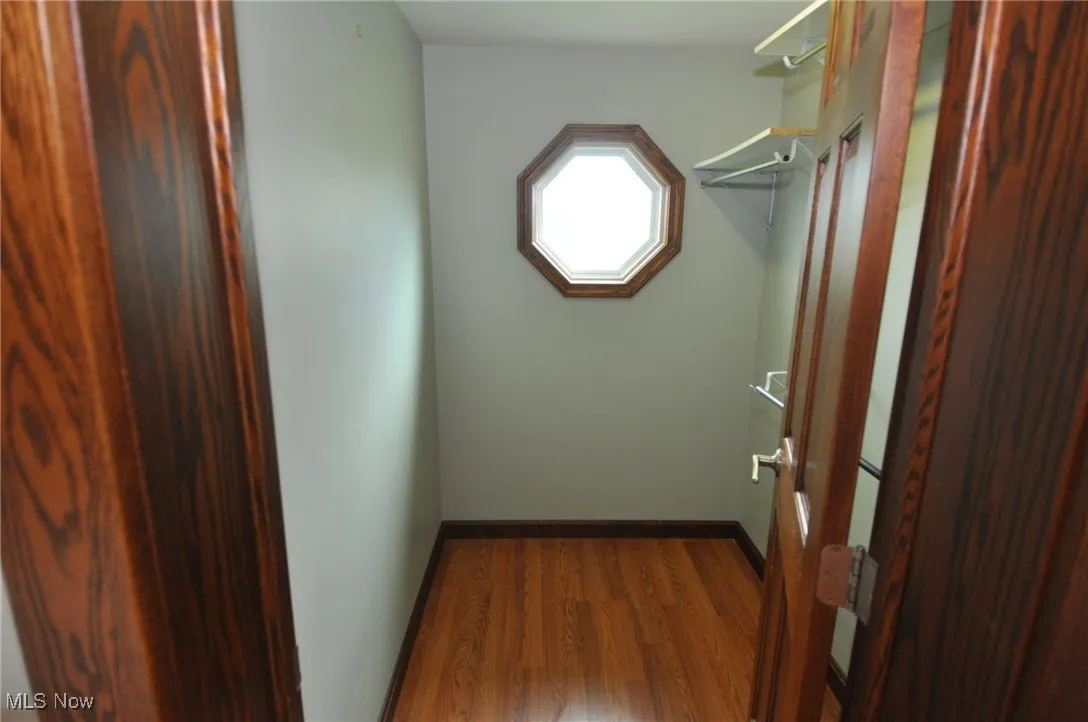 Primary bedroom's spacious closet with wood finished floors