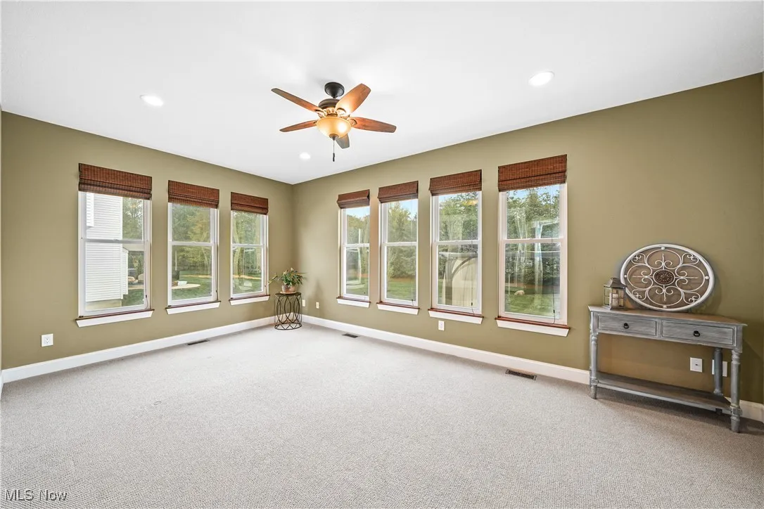 Carpeted empty room with a ceiling fan, healthy amount of natural light, baseboards, and recessed lighting