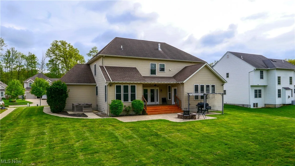 Rear view of house featuring an outdoor fire pit, a patio, french doors, a lawn, and ceiling fan