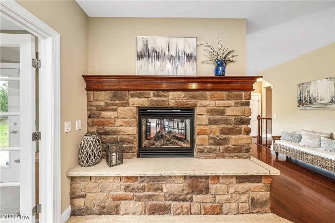 Detailed view of a stone fireplace and wood finished floors