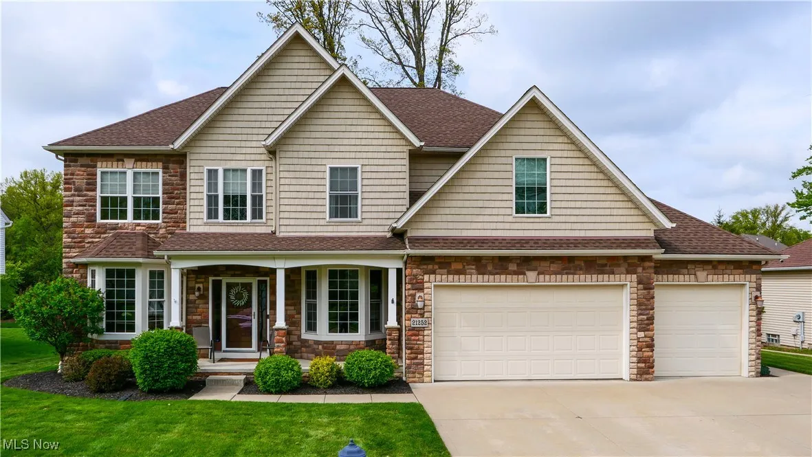 Craftsman-style house with driveway, roof with shingles, and a front yard