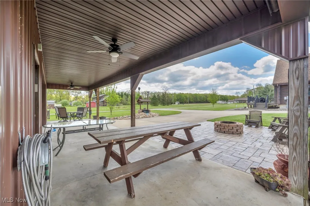 View of patio with an outdoor fire pit, ceiling fan, and outdoor dining area