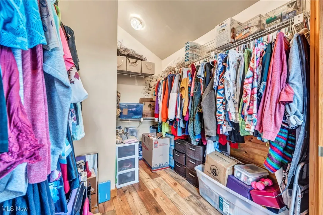Walk in closet with wood-type flooring and lofted ceiling