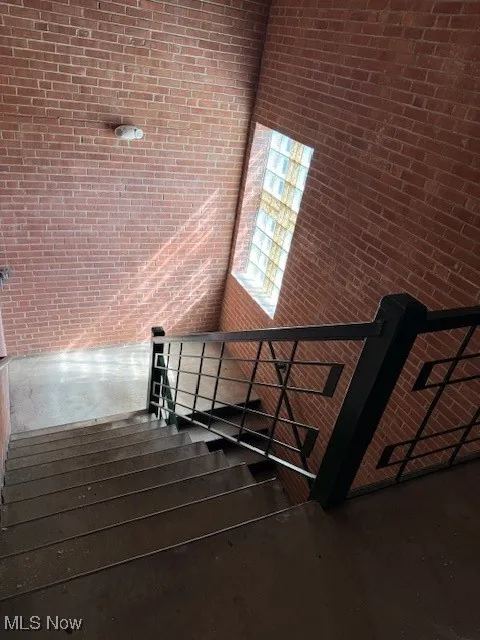 Stairs with brick wall and wood finished floors