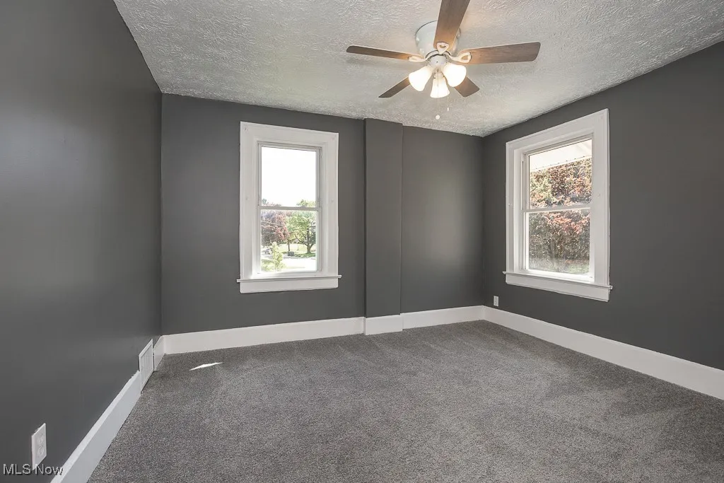 Bedroom featuring a textured ceiling, a ceiling fan, carpet floors, and baseboards