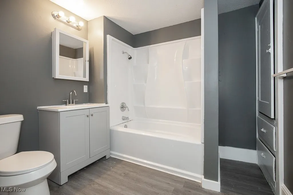 Full bath on 2nd floor featuring wood finished floors, toilet, shower / tub combination, and vanity