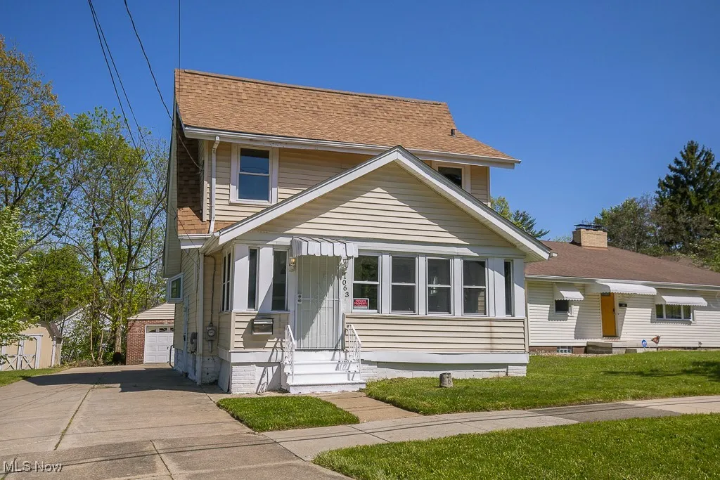 View of front of home featuring an outbuilding, entry steps, a front yard, and roof with shingles