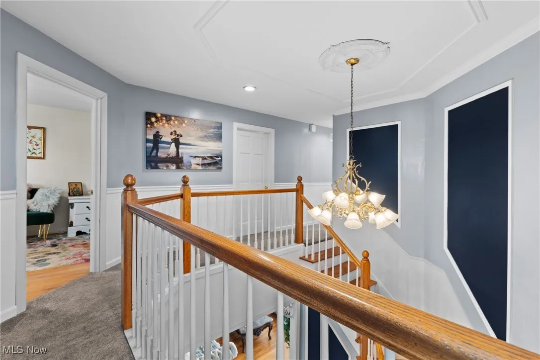 Corridor featuring an upstairs landing, recessed lighting, a chandelier, and carpet floors