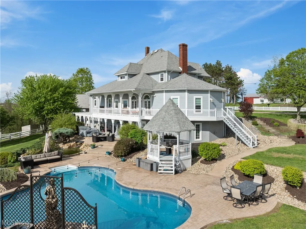 Rear view of house with a gazebo, a shingled roof, a patio, and outdoor lounge area