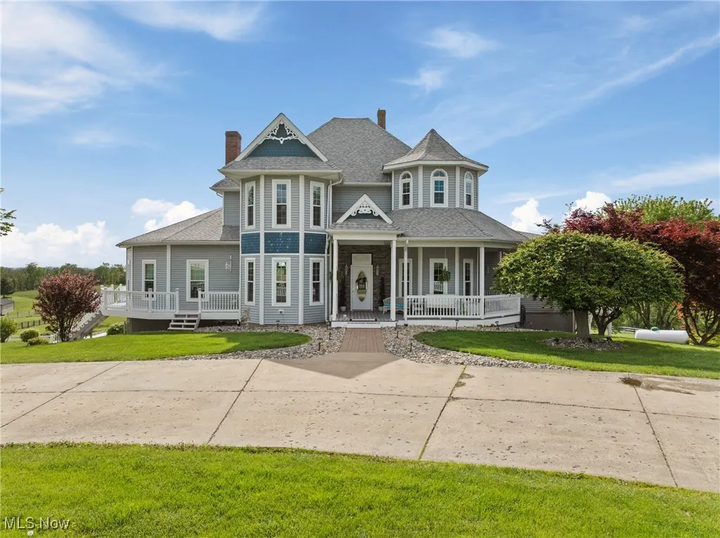Victorian home featuring covered porch, a front yard, a shingled roof, and a chimney