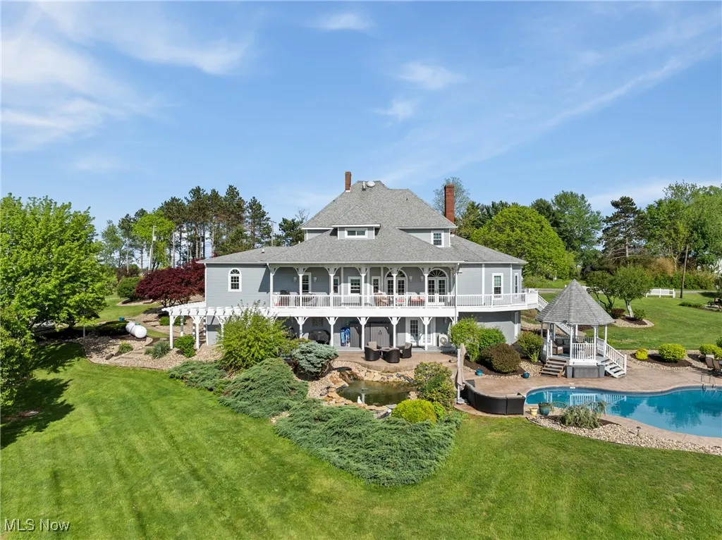 Rear view of house featuring a gazebo, a yard, an outdoor pool, a pergola, and a chimney