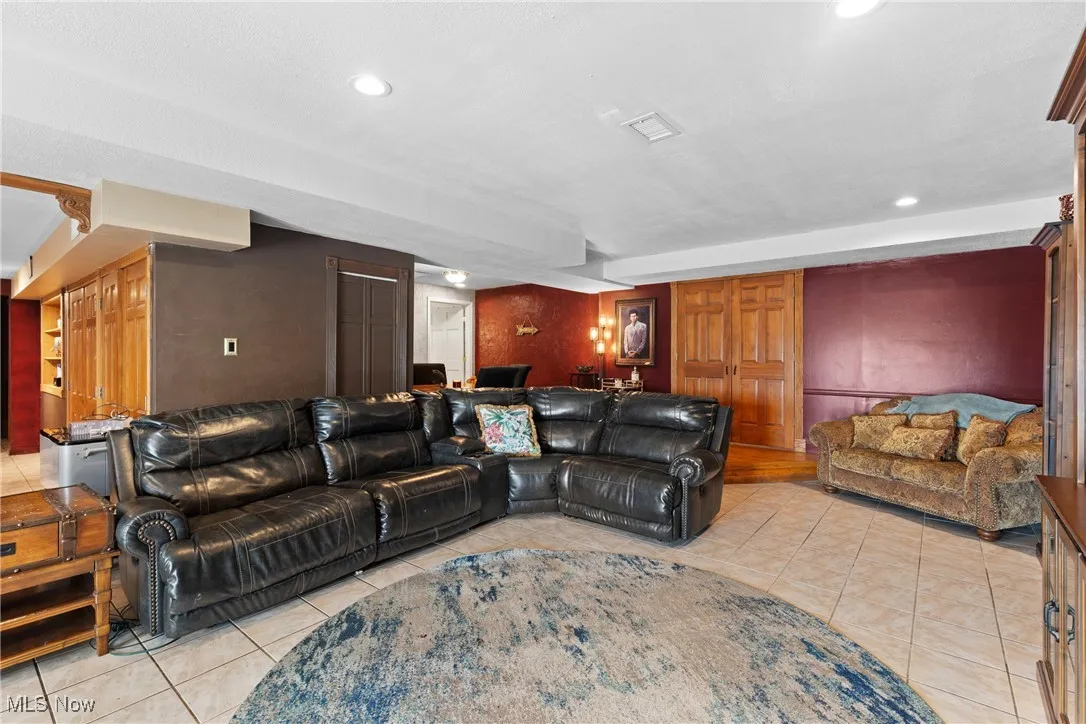 Living room with light tile patterned floors and recessed lighting