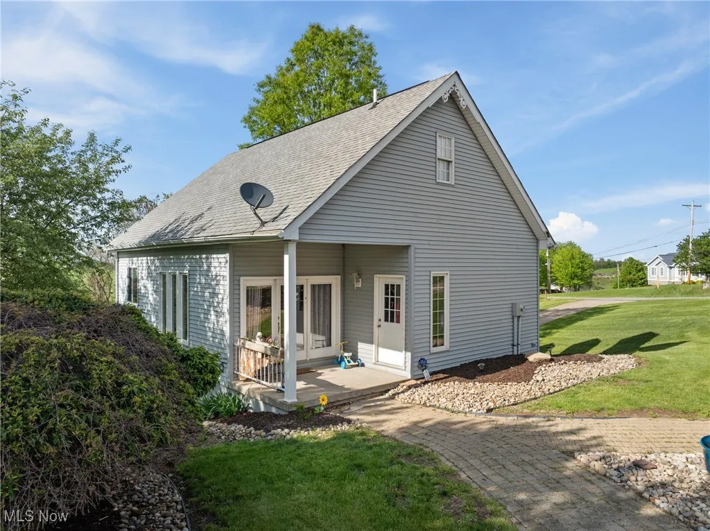 Rear view of house featuring a yard and a shingled roof